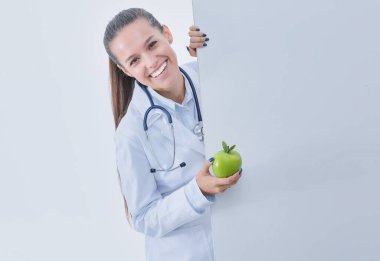 Elmalı ve boş pankartıyla gülümseyen doktor. Kadın doktorlar.