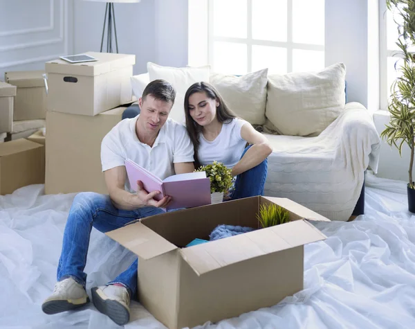 Casal bonito desempacotar caixas de papelão em sua nova casa — Fotografia de Stock