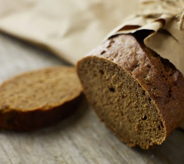 Sliced loaf of Bread packed in paper on wooden table