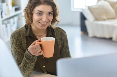 Evde tablet bilgisayar kullanan genç bir kadın ya da öğrenci