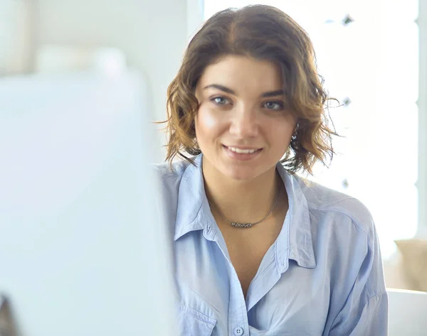 Hezká mladá žena sedí za stolem a píše na notebook — Stock fotografie