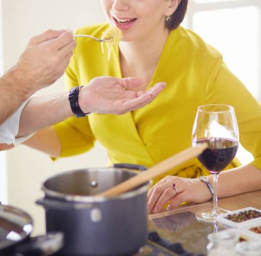 Evdeki mutfakta birlikte yemek pişiren çift.