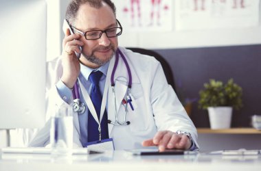 Masada oturan kıdemli doktorun portresi.