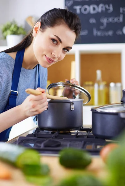 Cozinhar mulher na cozinha com colher de madeira — Fotografia de Stock