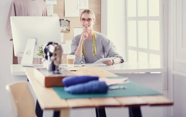 Mooi jong meisje in een fabriek met een naaimachine aan de tafel — Stockfoto