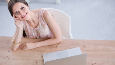 İş kadını ellerini başının arkasına koyup bir sandalyeye oturarak rahatlıyor. iş kadını