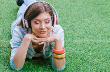 Yeşil çimlerde oturan genç bir kadın. Portreit genç bayan