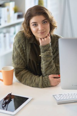 Öğrenci laptopla çalışıyor ve evdeki masada oturuyor.