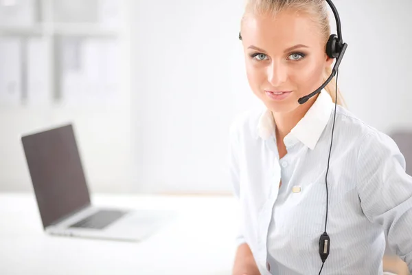 Portrait of smiling receptionist using laptop computer and headset at office desk — Stock Photo, Image