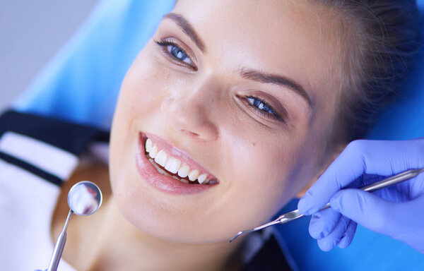 Young Female patient with pretty smile examining dental inspection at dentist office.