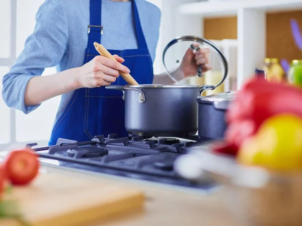 Mujer cocinera en cocina con cuchara de madera — Foto de Stock