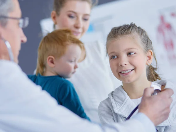 Chica y médico con estetoscopio escuchando los latidos del corazón — Foto de Stock