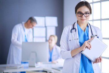 Hastane lobisinde tablet bilgisayar kullanan kadın doktor.