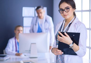 Kadın doktor hastanede steteskopla dikiliyor.