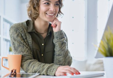 Dizüstü bilgisayarda eğitim kursuna bakan genç bir kadın.