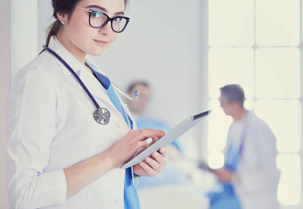 Médico femenino usando tableta en el vestíbulo del hospital —  Fotos de Stock