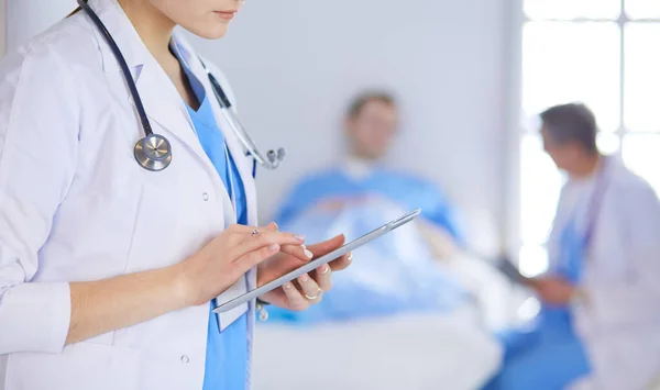 Женщина-врач, использующая планшетный компьютер в холле больницы — стоковое фото