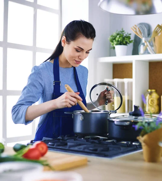 Mujer cocinera en cocina con cuchara de madera — Foto de Stock