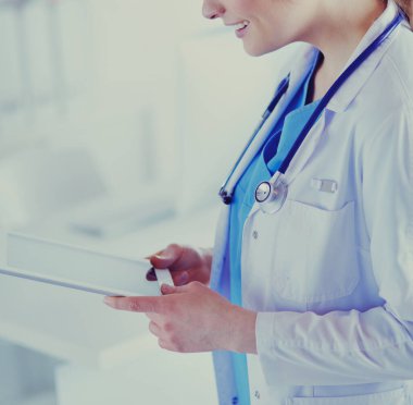 Hastane lobisinde tablet bilgisayar kullanan kadın doktor.