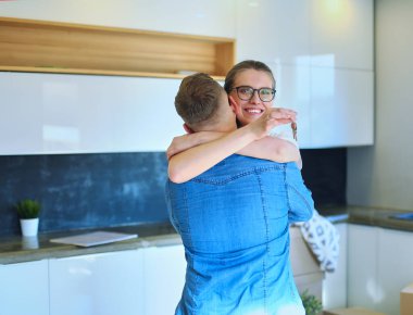 Mutlu çift yeni evlerinde sarılıyor.