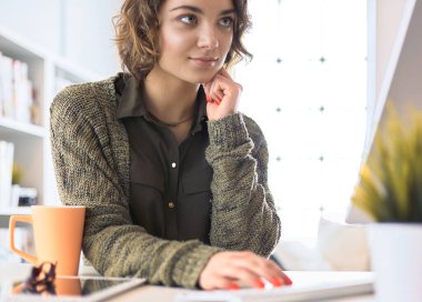 Dizüstü bilgisayarda eğitim kursuna bakan genç bir kadın.