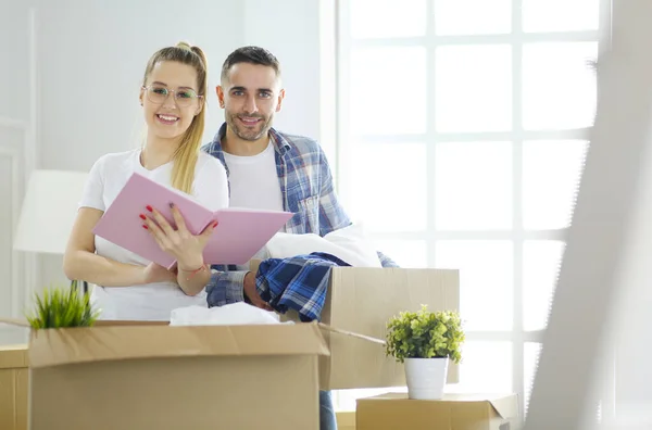 Ein frisch verheiratetes Paar packt Kartons aus und bezieht ein neues Zuhause. Positive Emotionen. — Stockfoto