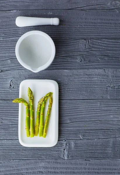 Grüner frisch geschälter Spargel in einer Porzellanschüssel — Stockfoto