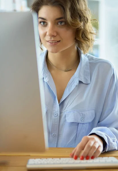 Happy woman working using multiple devices on a desk at home