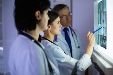 Bir grup doktor hastanede röntgenleri inceliyor.