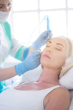 Kaşlar için kalıcı makyaj. Güzellik salonunda kalın kaşlı güzel bir kadın.