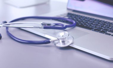 Tıbbi ekipman: Beyaz arka planda mavi steteskop ve tablet. Tıbbi ekipman