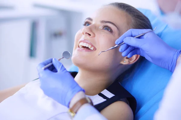 Mujer joven con la boca abierta examinando la inspección dental en el consultorio del dentista. — Foto de Stock