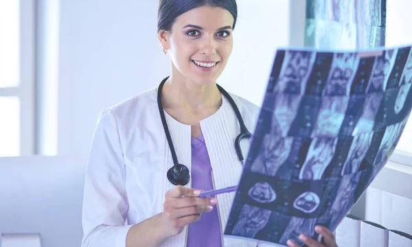 Jeune femme médecin souriante avec stéthoscope regardant les rayons X au bureau des médecins — Photo