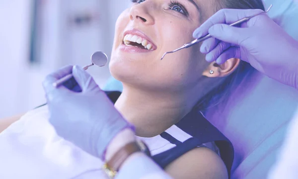 Mujer joven con la boca abierta examinando la inspección dental en el consultorio del dentista. — Foto de Stock