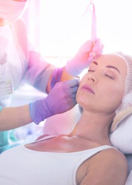 Kaşlar için kalıcı makyaj. Güzellik salonunda kalın kaşlı güzel bir kadın..