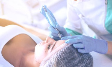 Kaşlar için kalıcı makyaj. Güzellik salonunda kalın kaşlı güzel bir kadın.