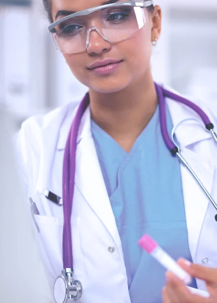 Kvindelig forsker er omgivet af medicinske hætteglas og kolber, iso - Stock-foto