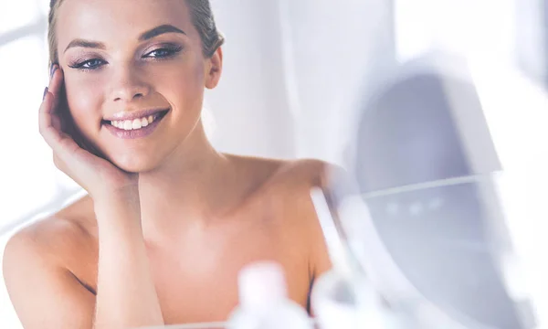 Junge Frau im Bademantel blickt in Badezimmerspiegel — Stockfoto