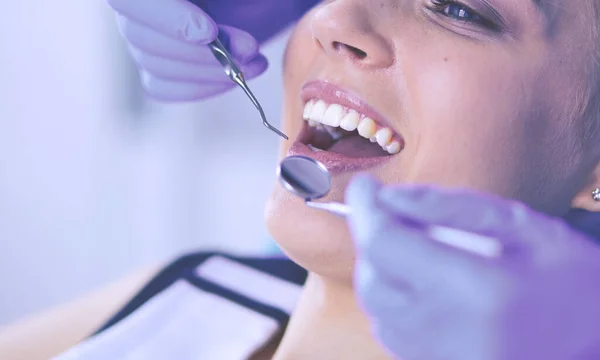 Mujer joven con la boca abierta examinando la inspección dental en el consultorio del dentista. — Foto de Stock