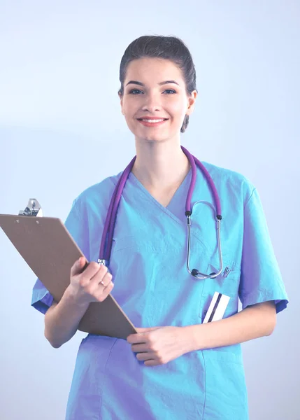 Médecin souriante avec un dossier en uniforme debout à l'hôpital — Photo