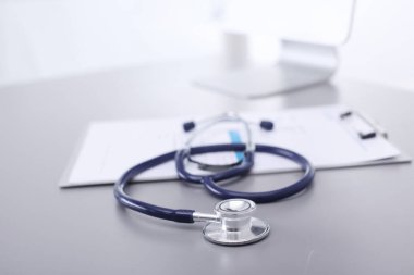 Tıbbi ekipman: Beyaz arka planda mavi steteskop ve tablet. Tıbbi ekipman