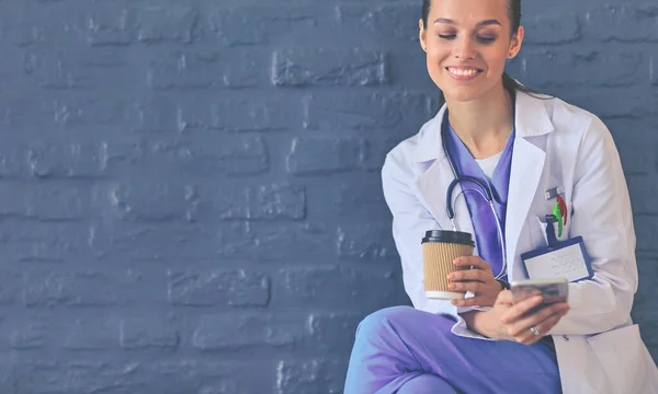 Een jonge vrouwelijke dokter die bij je telefoon zit. Vrouwelijke artsen. — Stockfoto