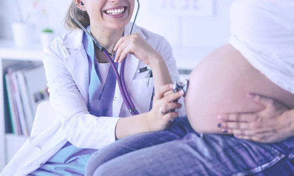 Mujer sonriente médico muestra imágenes en la tableta a la mujer joven embarazada en el hospital. — Foto de Stock