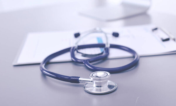 Медицинское оборудование: синий стетоскоп и таблетка на белом фоне. Медицинское оборудование