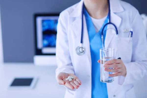 Közelkép orvosokról, akik tablettákat és pohár vizet tartanak a kezükben.. — Stock Fotó