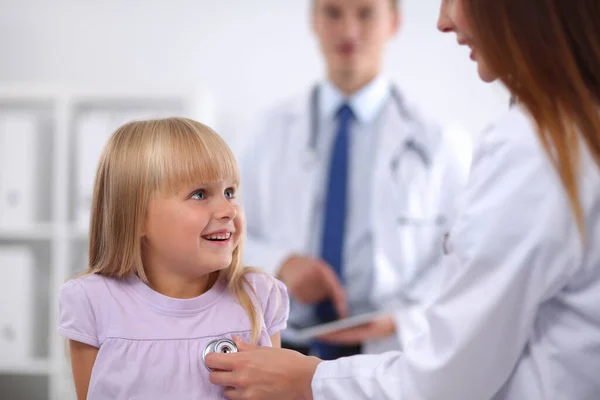 Female doctor examining child with stethoscope at surgery — Stock Photo, Image