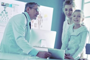 Küçük tatlı bir kız ve hastanedeki doktorunun portresi.