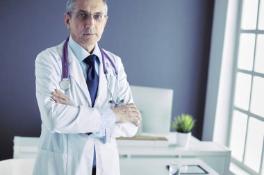 Parlak ofisinde gülümseyen bir doktorun portresi.