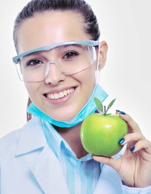 Yeşil elmalı gülümseyen kadın doktor.