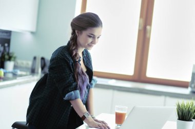 Güzel, genç, gülümseyen bayan doktor masada oturuyor ve yazıyor..